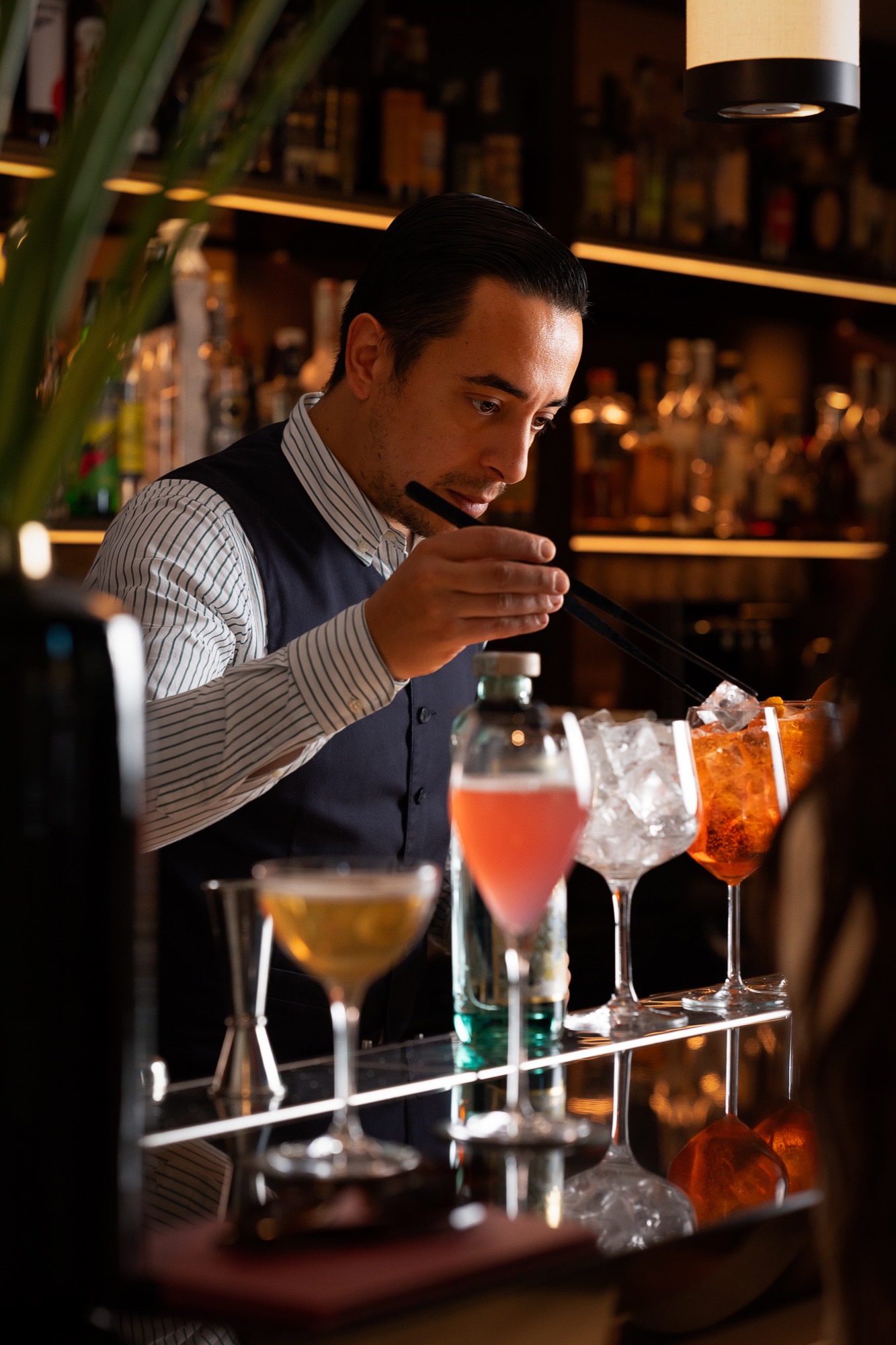 Cocktail bar photography featuring a bartender at work by Nicco Leone